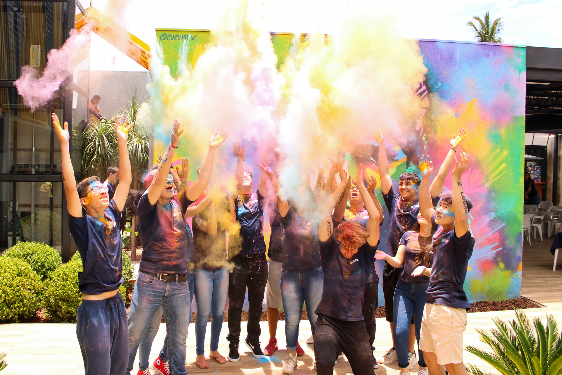 Alunos do Colégio Status celebrando com festival de cores